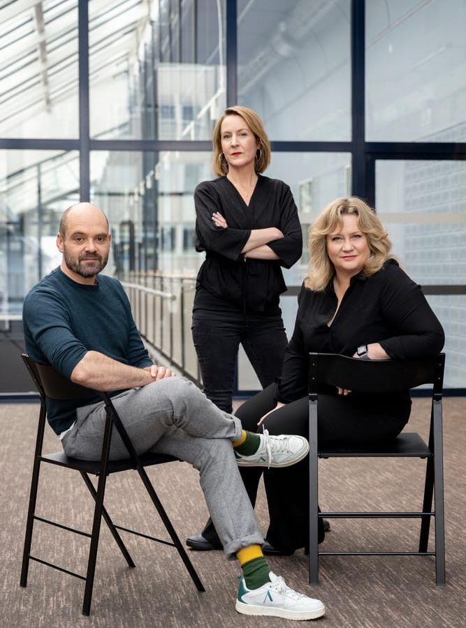 Regissören Sanna Lenken omgiven av skådespelarna David Dencik och Maria Sid. SVT:s nya drama 'Smärtpunkten' om Lars Noréns ödesdigra teaterprojekt '7:3', har premiär den 19 april.