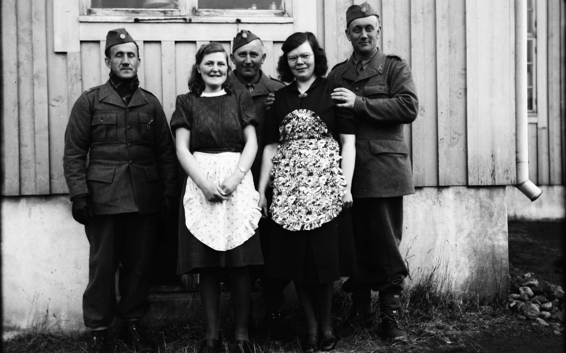 Tre beredskapsmän och två kvinnor, som av förklädena att döma hade kökstjänst, fotograferade av Erik ”Kloar-Erik” Andersson.