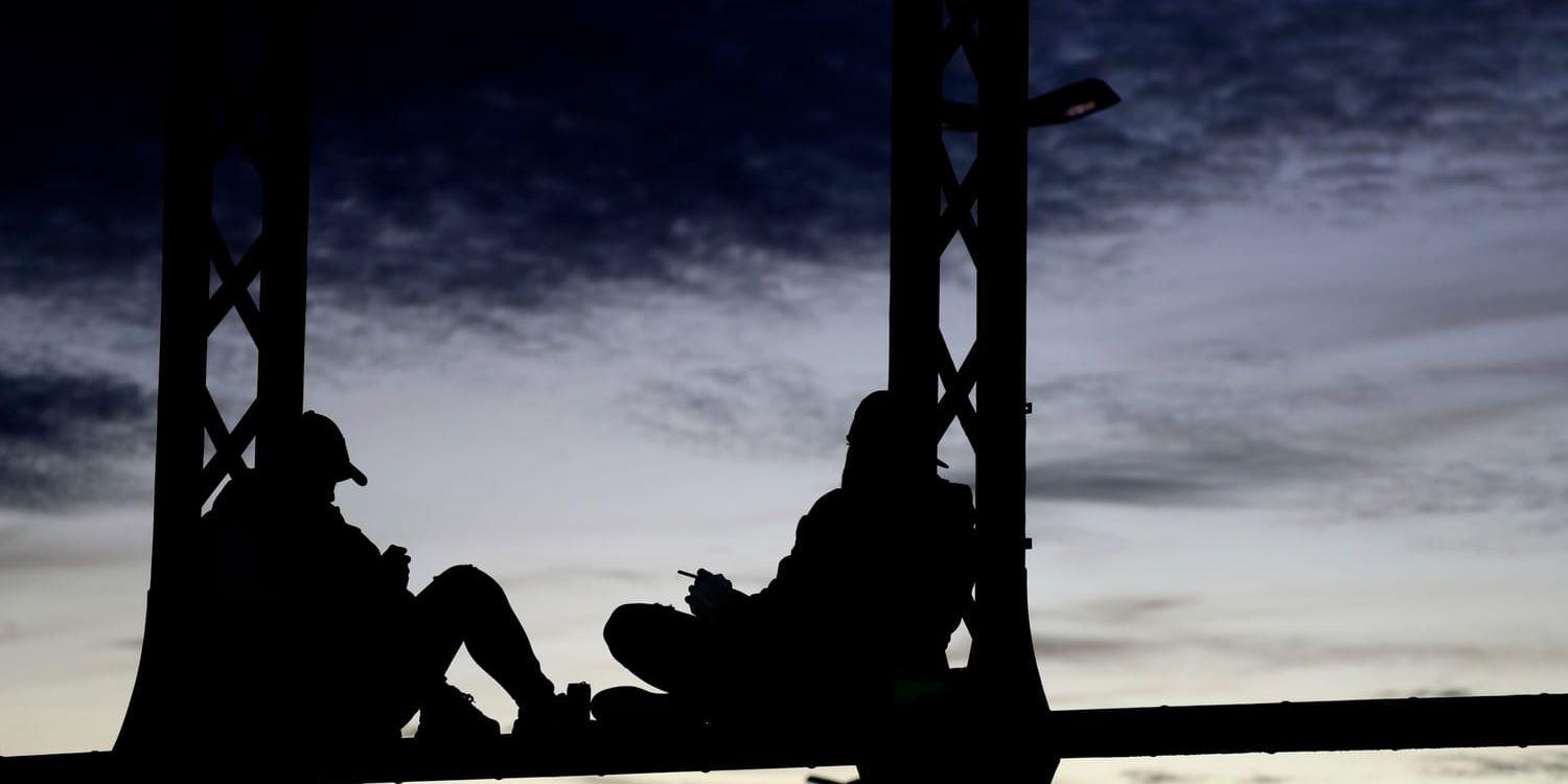 Young people enjoy a warm autumn evening at the bridge 'Hackerbruecke' in Munich, Germany, Monday, Nov. 2, 2020. (AP Photo/Matthias Schrader)